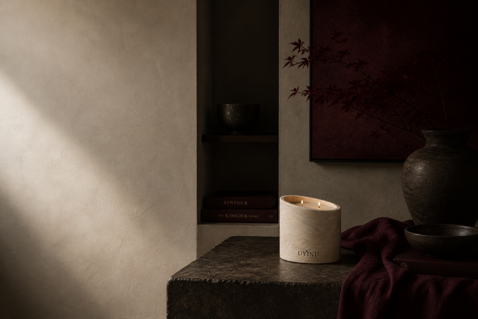 uyinu no. 01 sacred pause refillable candle beside deep wine fabric